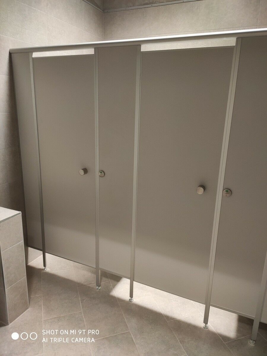 Две туалетные кабинки с дверью серого цвета